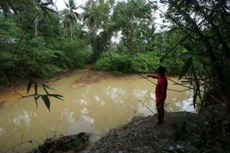 Warga sekitat Pulau Merah menunjukkan tumpukan lumpur di sungai yang bermuara di tempat wisata Pantai Pulau Merah Jumat (19/8/2016)