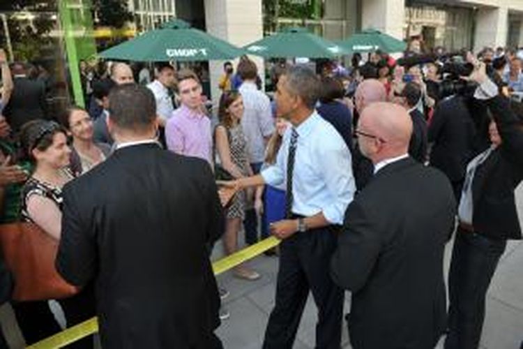 Presiden Amerika Barack Obama (tengah berbaju putih tanpa jas) berjalan kaki dari Gedung Putih ke warung sandwich yang memberi diskon 10 persen selama 
