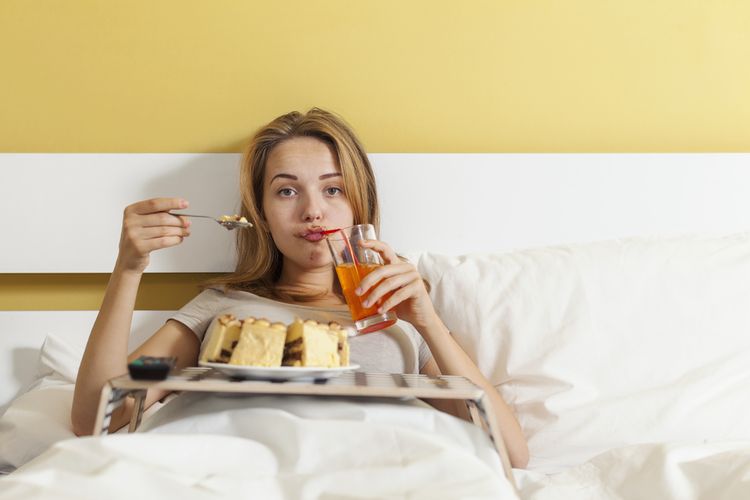 Ilustrasi makan di tempat tidur. Kebiasaan makan di tempat tidur bisa menjadi penyebab munculnya semut. 