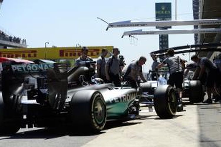 Pebalap Mercedes asal Inggris, Lewis Hamilton (kiri), masuk ke pit tepat di belakang rekan satu timnya, Nico Rosberg, pada sesi latihan kedua GP Spanyol di Sirkuit Catalunya, Jumat (9/5/2014).