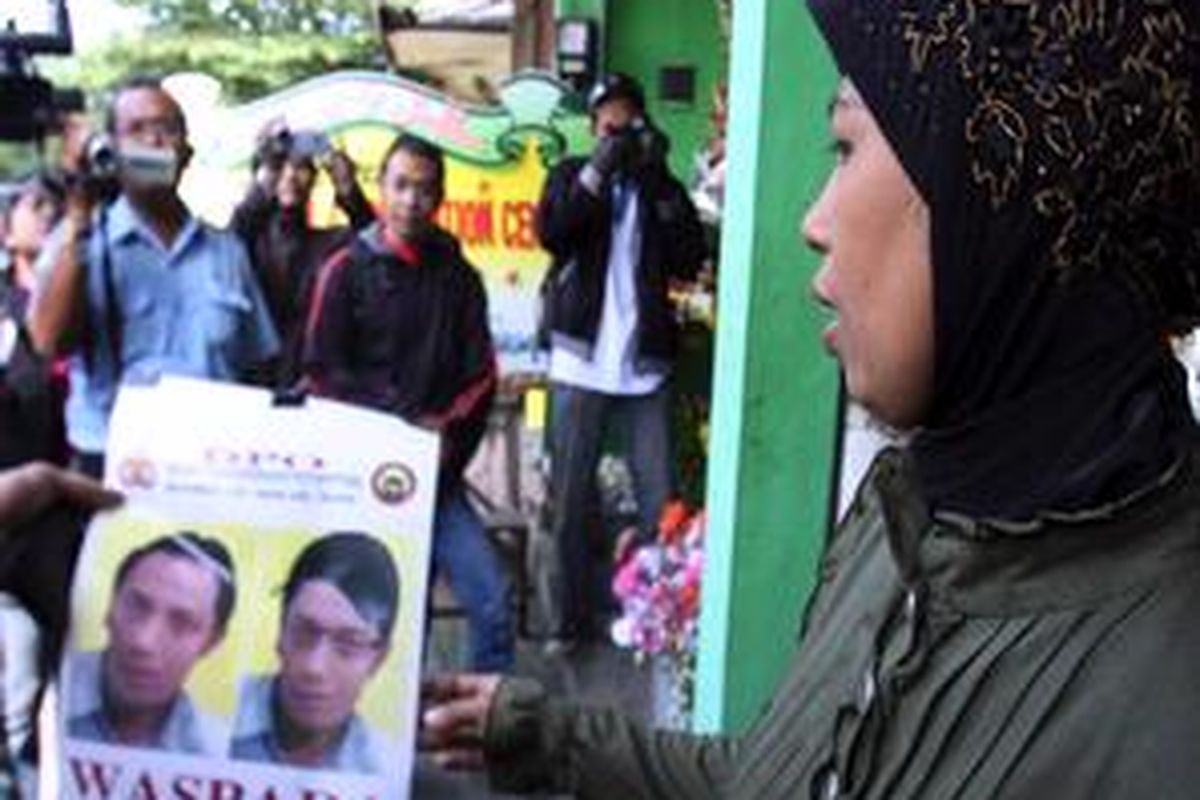 Seorang warga memegangi foto Ibrohim.