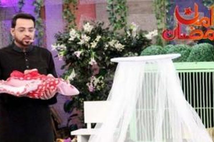 Aamir Liaquat Hussain, seorang pembawa acara televisi di Pakistan, menggelar acara bincang-bincang dengan hadiah kuis seorang bayi.