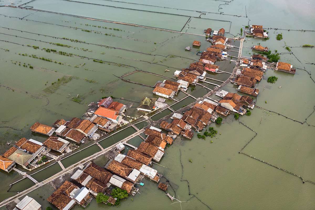 Foto udara permukiman penduduk yang terkepung air laut akibat abrasi di Desa Timbulsloko, Sayung, Demak, Jawa Tengah, Kamis (14/3/2019). Abrasi yang mengikis garis pantai Kabupaten Demak sekitar tahun 1995 berdampak pada peralihan fungsi lahan setempat yang awalnya merupakan areal pertanian produktif berangsur menjadi tambak ikan dan sebagian kini telah menjadi perairan akibat kenaikan permukaan air laut disertai penurunan permukaan tanah mencapai sekitar 10 sentimeter per tahun.