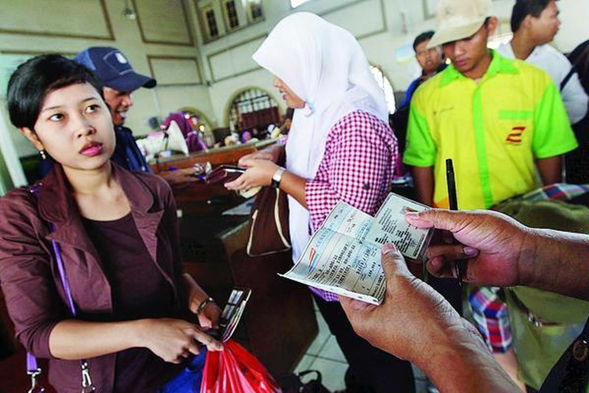 Petugas mencocokkan identitas calon penumpang dengan nama yang tertera di tiket Kereta Api Singosari tujuan Malang, Jawa Timur, di Stasiun Pasar Senen, Jakarta Pusat, Kamis (9/8). Pada arus mudik tahun ini, PT Kereta Api Indonesia tidak menjual tiket berdiri sehingga semua penumpang yang telah memiliki tiket dipastikan mendapatkan tempat duduk.