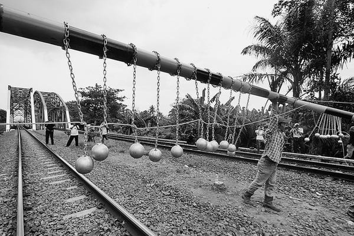 PT KAI Daop I memasang palang dengan bandul bola beton di jalur kereta selepas Stasiun Besar Bekasi  sekitar Kilometer 27.100, Bekasi, Jawa Barat, Selasa (17/1). Sebanyak 24 bola beton dengan berat masing-masing 2 kilogram itu dipasang di konstruksi serupa gawang untuk mencegah penumpang naik ke atap saat melakukan perjalanan dengan kereta api.