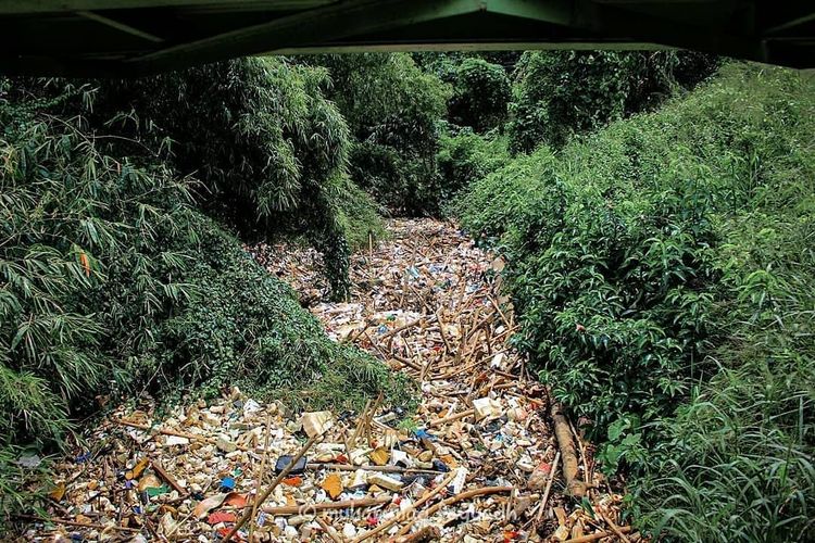 Sebuah foto viral di media sosial setelah menampilkan foto tutupan sampah yang menumpuk di aliran Kali Licin, Jalan Pitara Raya, Cipayung, Depok, Jawa Barat. Foto diambil Rabu (19/2/2020).
