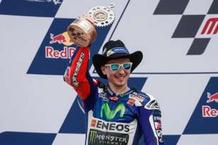 Pebalap Movistar Yamaha asal Italila, Jorge Lorenzo, mengangkat trofi yang didapat setelah finis kedua pada GP Americas di Circuit of The Americas (COTA), Austin, Minggu (10/4/2016).