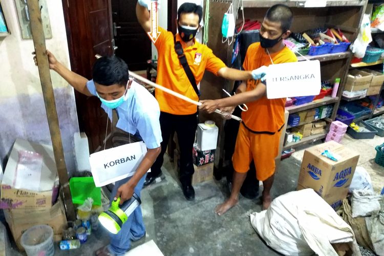 Tersangka Y memeragakan pemukulan terhadap korban, Bisri Efendi (71), pemilik toko di Blitar yang ditemukan tewas Sabtu dua pekan lalu. Polisi, dihadiri jaksa dan pengacara, menggelar rekonstruksi di TKP di Desa Jatinom, Kecamatan Kanigoro, Kabupaten Blitar, Jawa Timur, Rabu (10/3/2021) 