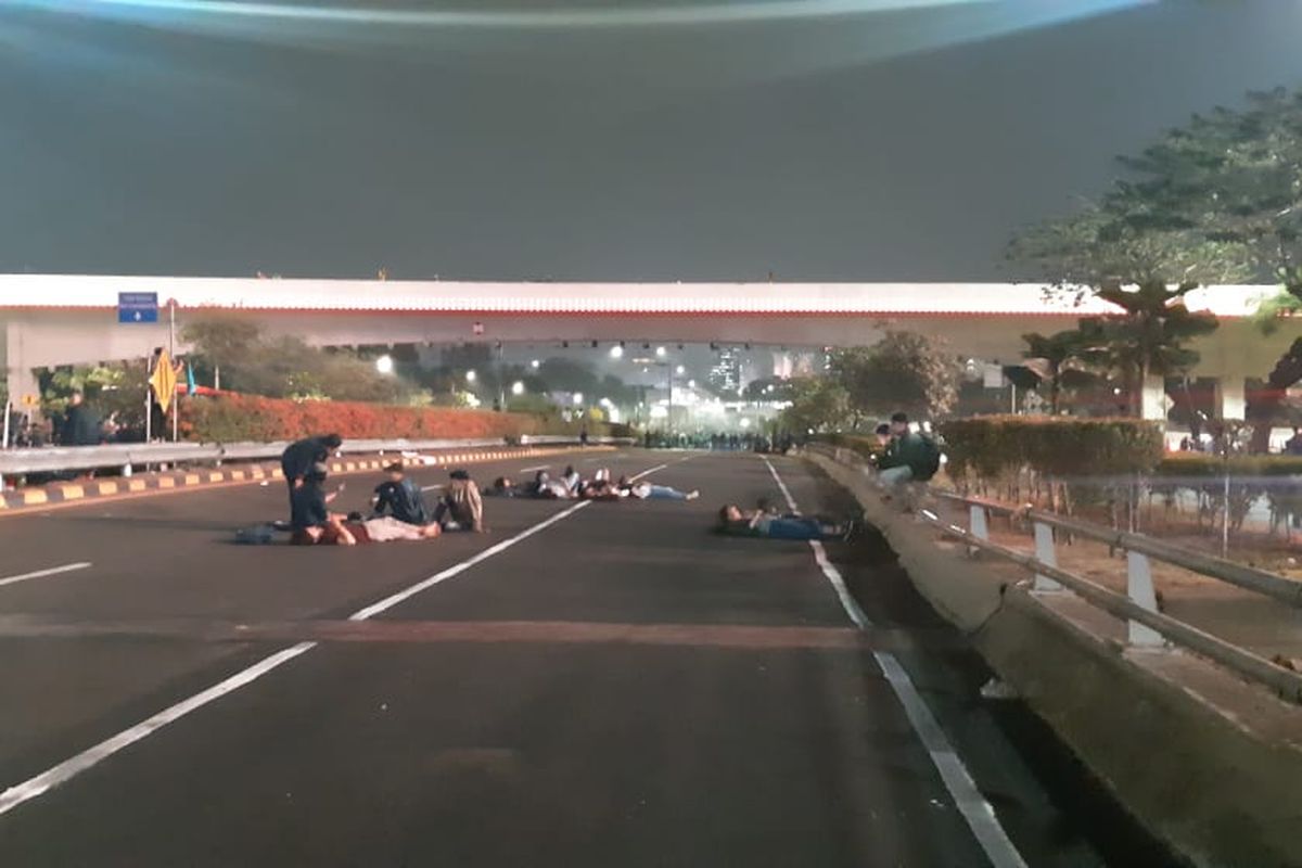 Beberapa mahasiwa memanfaatkan ditutupnya jalan tol dalam kota Jakarta untuk berstirahat. Mereka ada yang duduk, bermain HP, bahkan tiduran di jalan untuk melepas lelah setelah seharian berunjuk rasa di Gedung DPR/MPR, Selasa (24/9/2019).
