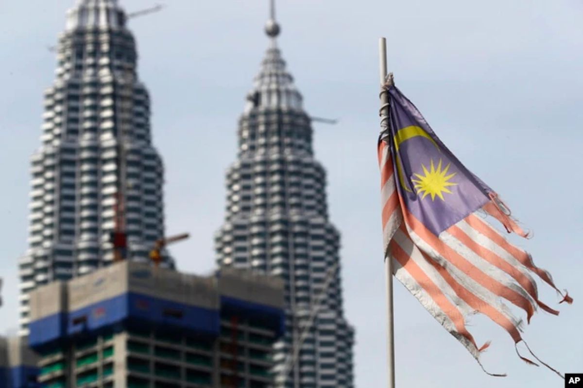 Bendera nasional Malaysia yang rusak terlihat berkibar di depan Menara Petronas di Kuala Lumpur, Malaysia.