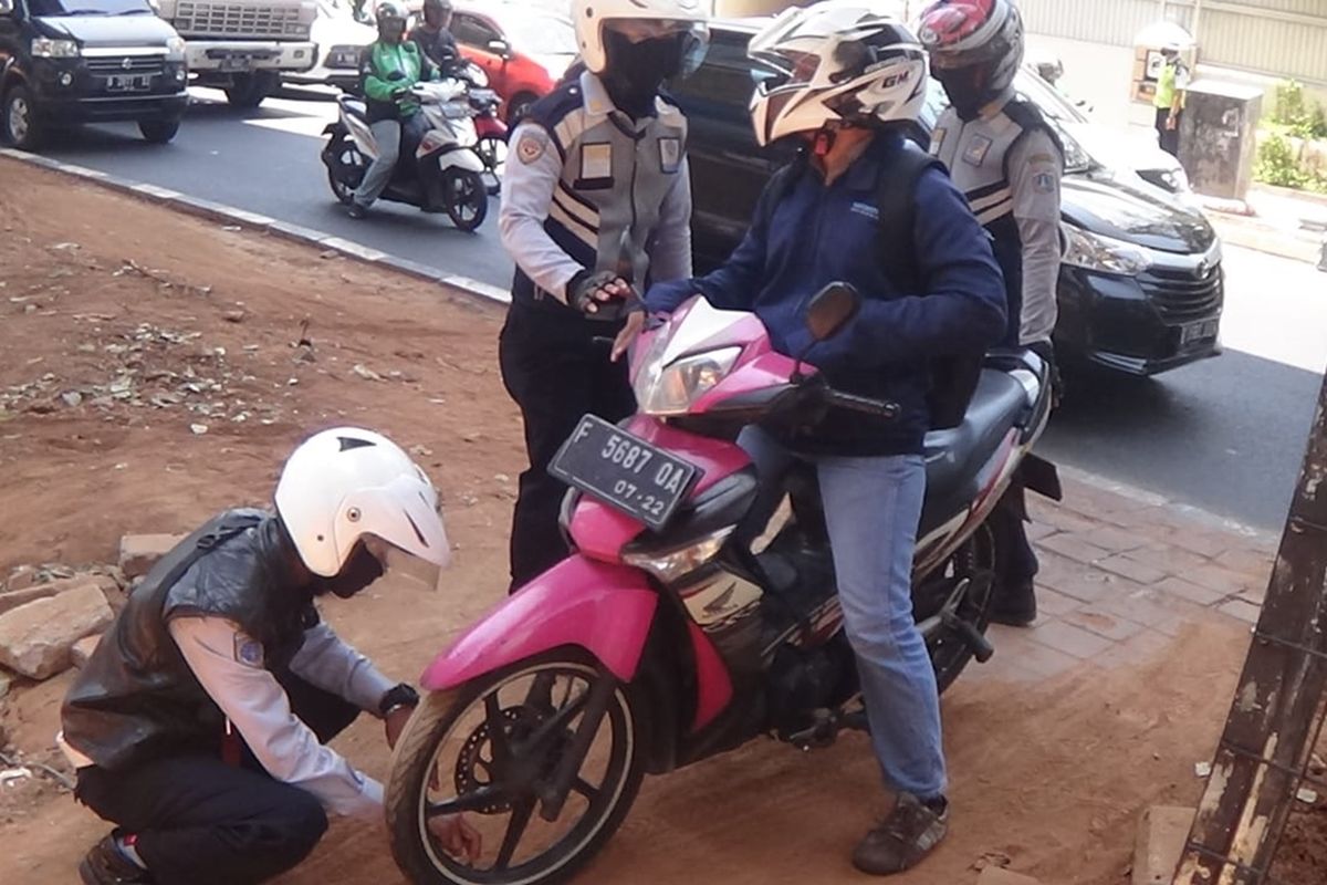 Petugas Dishub lakukan sanksi cabut pentil kepada pengendara motor yang parkir dan memutar jalan di area hijau Jalan Doktor Satrio, Kuningan, Jakarta Selatan, (22/10/2019).