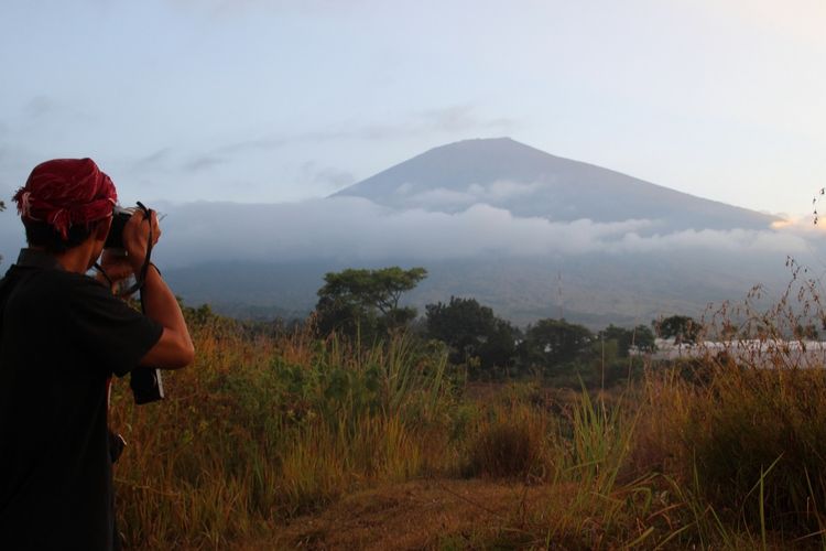 Lombok, Kompas.Com-Seorang wisatawan memotret keindahan  Gunung Rinjani dari Desa Sembalun Lawang, Lombok Timur. Hari ini Gunung Rinjani telah resmi dibuka kembali bagi wisatawan, paska gempa Agustus 2018 silam.