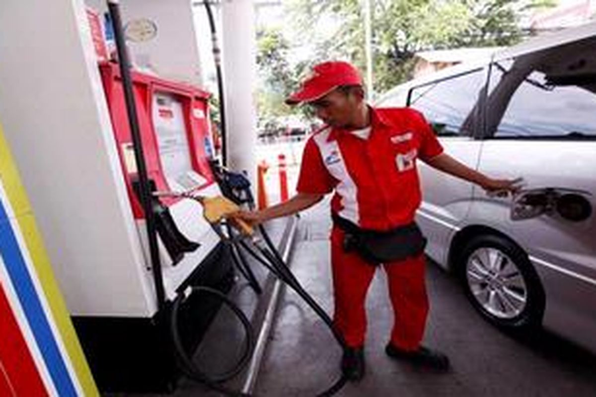 Petugas mengisi bahan bakar minyak (BBM) bersubidi ke kendaraan pribadi mewah di Stasiun Pengisian Bahan Bakar Umum (SPBU) 31.127.02, Jakarta Selatan, Sabtu (30/3/2013). Badan Pengatur Hilir Minyak dan Gas Bumi mengkaji sejumlah opsi untuk menekan konsumsi bahan bakar minyak bersubsidi agar tak melampaui kuota dalam Anggaran Pendapatan dan Belanja Negara 2013 yang ditetapkan 46 juta kiloliter. 