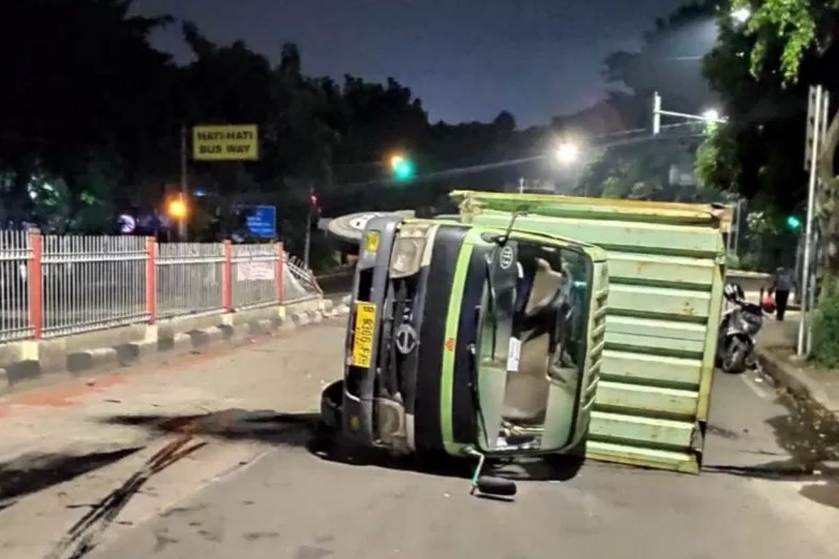 Truk boks bermuatan sembako terguling di Jalan Raya Pondok Gede, Kramat Jati, Jakarta Timur, Minggu (5/4/2020). Petugas evakuasi menyebutkan truk berbobot 13 ton itu mengangkut sembako untuk dipasok menuju minimarket di Jakarta. 
