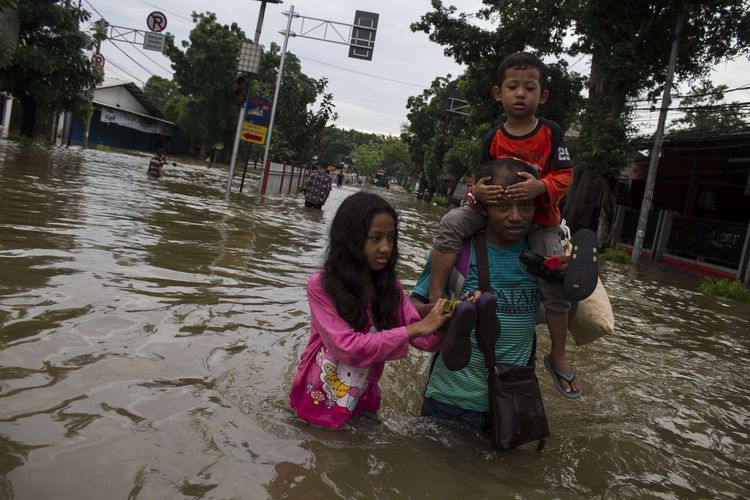 Sejumlah warga mengevakuasi korban yang terendam banjir di Jl. Raya Pondok Gede, Kramat Jati, Jakarta Timur, Rabu (1/1/2020). Luapan air Kali Baru sebabkan wilayah Kramat Jati terendam hingga sebahu orang dewasa.