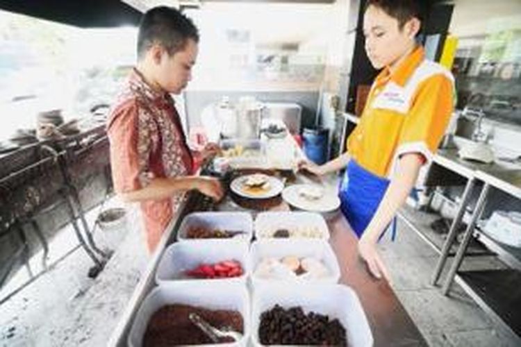 Karyawan restoran Soerabi Bandung HNH sedang memanggang serabi dalam tembikar-tembikar kecil, Jumat (13/9/2013) di restoran Soerabi Bandung HNH Jalan KH Ahmad Dahlan, Kebayoran Baru, Jakarta Selatan.