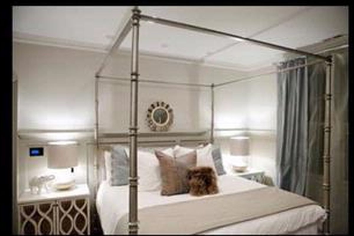 Dinding abu-abu dan gorden dengan warna senada dapat menarik mata Anda kepada pusat ruangan, yaitu sebuah tempat tidur kontemporer dengan aksen menarik.