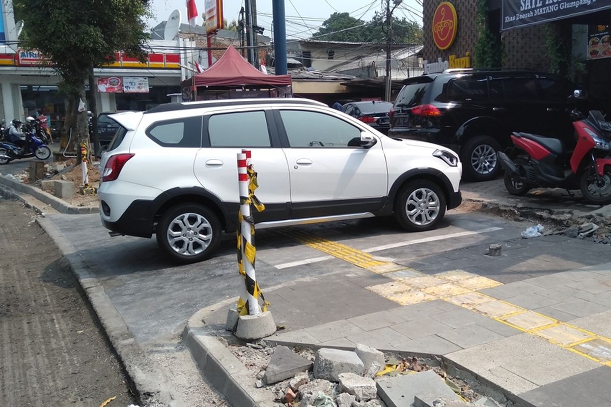 Mobil dan sepeda motor parkir di trotoar Jalan Kemang Raya, Mampang, Jakarta Selatan, Jumat (23/8/2019). Trotoar di kawasan Kemang sedang direvitalisasi.