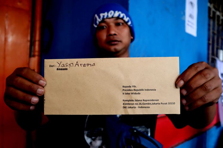 Salah satu suporter Arema FC, menunjukkan surat yang dibawa saat aksi kirim Surat dari Aremania untuk Presiden Jokowi Menuntut Usut Tuntas Tragedi Kanjuruhan di Kantor Pos Kota Malang, Kamis (17/11/2022) siang.
