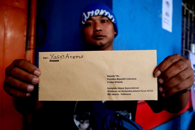 Salah satu suporter Arema FC, menunjukkan surat yang dibawa saat aksi kirim Surat dari Aremania untuk Presiden Jokowi Menuntut Usut Tuntas Tragedi Kanjuruhan di Kantor Pos Kota Malang, Kamis (17/11/2022) siang.