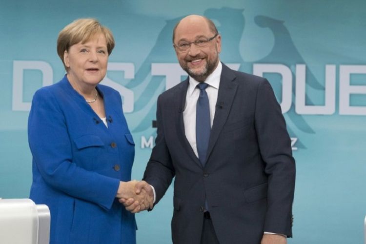 Kanselir Jerman Angela Merkel bersalaman dengan lawannya Mantan Presiden Parlemen Uni Eropa Martin Schulz di debat pemilihan umum Jerman, Minggu (4/9/2017)