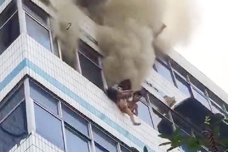 Inilah detik-detik saat seorang ibu akan melemparkan anaknya dari lantai empat sebuah apartemen yang terbakar di China.
