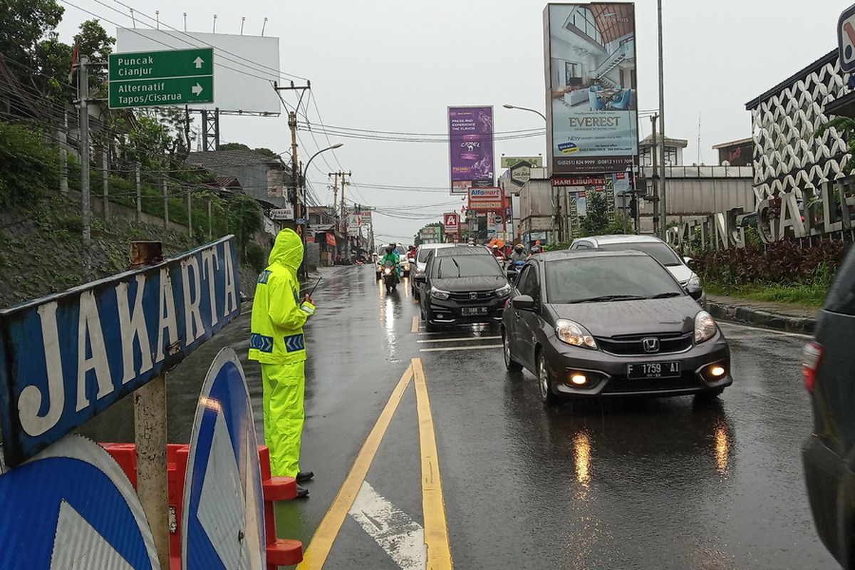 Anggota Satlantas Polres Bogor sedang mengatur arus lalu lintas di Jalan Raya Bogor, Simpang Gadog, Ciawi, Puncak Bogor, Jawa Barat, Sabtu (31/10/2020).