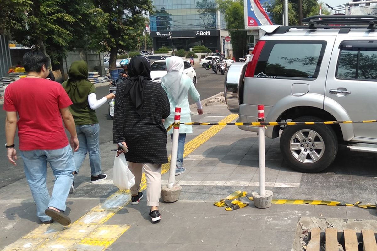 Mobil dan motor yang parkir diatas trotoar jalan Kemang Raya, Mampang, Jakarta Selatan, Jumat (23/8/2019). Akibatnya, beberapa warga merasa terganggu ketika berjalan di trotoar tersebut.