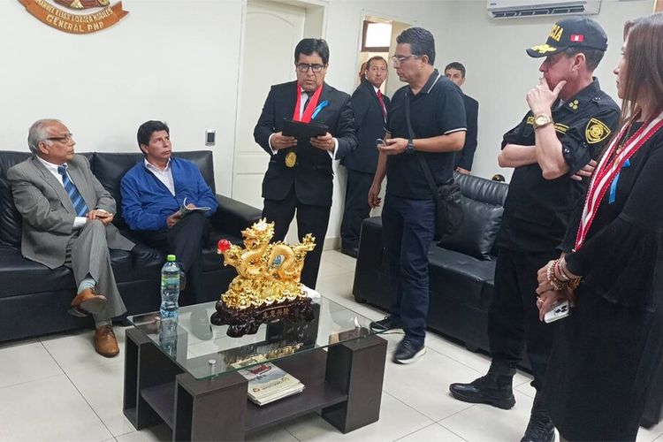 Dalam foto yang disediakan oleh kantor administrasi kepolisian Peru ini, mantan Presiden Pedro Castillo, kedua dari kiri, dan mantan Perdana Menteri Anibal Torres, paling kiri, duduk sebagai jaksa Marco Huaman berdiri di tengah di dalam kantor polisi, di mana status Castillo dan Torres tidak segera jelas, di Lima, Peru, Rabu, 7 Desember 2022.