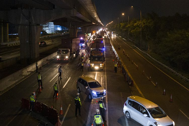 Petugas kepolisian mengarahkan kendaraan pribadi yang melintas di tol Jakarta-Cikampek untuk keluar melalui pintu tol Cikarang Barat 3, Jawa Barat, Kamis (21/5/2020). Petugas gabungan memberlakukan penyekatan gelombang pemudik jelang perayaan Hari Raya Idul Fitri 1441 H dari arah Jakarta menuju Jawa Tengah.