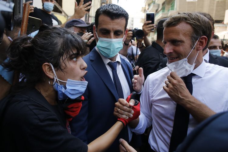 Presiden Perancis, Emmanuel Macron mendengarkan seorang penduduk saat dia mengunjungi jalan yang hancur di Beirut, Lebanon, Kamis 6 Agustus 2020. Presiden Perancis Emmanuel Macron telah tiba di Beirut untuk menawarkan dukungan Perancis kepada Lebanon setelah ledakan pelabuhan yang mematikan itu.