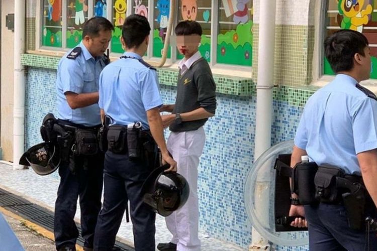 Potongan rekaman video memperlihatkan dua polisi Hong Kong menghadapi seorang pelajar dengan mulut berlumuran darah setelah diserbu di taman bermain Selasa (3/9/2019).