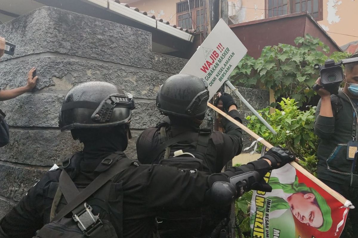 Military and police personnel take down FPI banners, posters and other images following the groupss disbanding on Wednesday (30/12/2020)