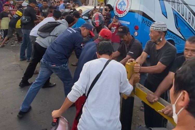 Warga menjebol palang besi yang menutup lintasan kereta api di Losari Lodoyong Ambarawa.