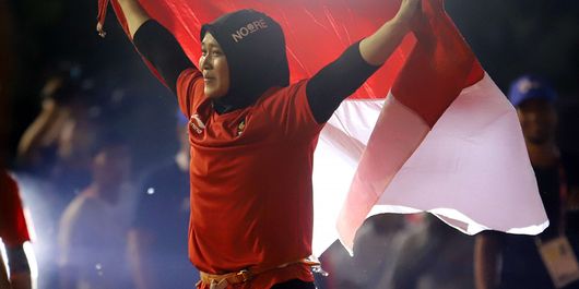 Atlet panjat tebing Indonesia Aries Susanti Rahayu mengibarkan Bendera Merah Putih setelah berhasil meraih medali emas pada kategori speed Asian Games 2018 di Arena Panjat Tebing Jakabaring Sport City, Palembang, Sumatera Selatan, Kamis (23/8/2018).