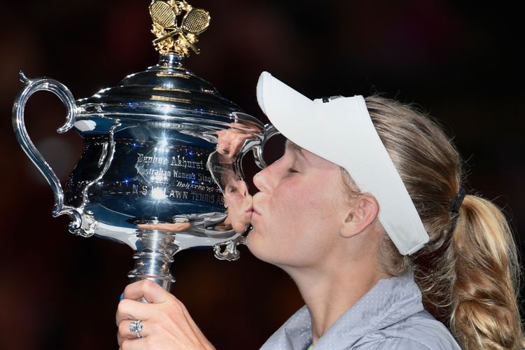 Petenis asal Denmark, Caroline Wozniacki, mencium trofi Australia Terbuka setelah mengalahkan pemain Romania, Simona Halep, pada babak final di Rod Laver Arena, Sabtu (27/1/2018).