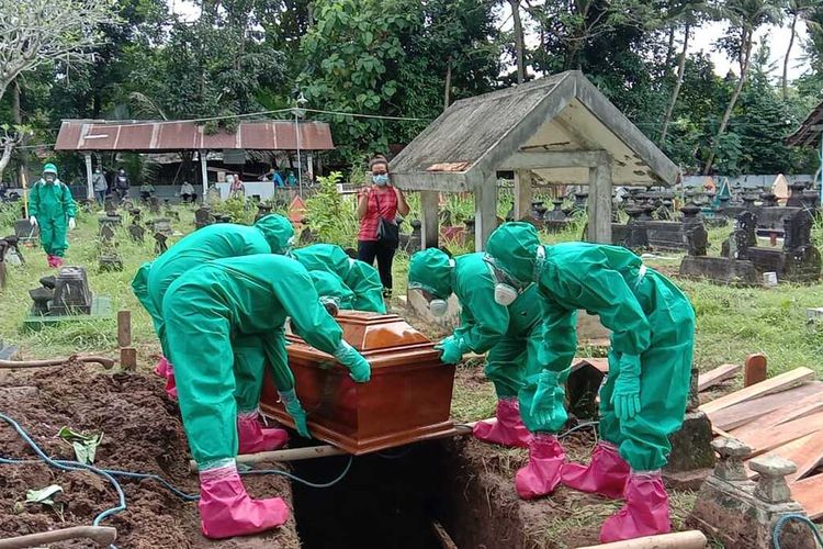 Pemakaman dengan protokol Covid-19 untuk seorang warga di Pedukuhan Pntog Kulon, Banjaroyo, Kapanewon Kalibawang, Kulon Progo, Daerah Istimewa Yogyakarta. Relawan pemakaman naik turun bukit dan lewat sungai untuk menuju lokasi pemakaman umum warga.