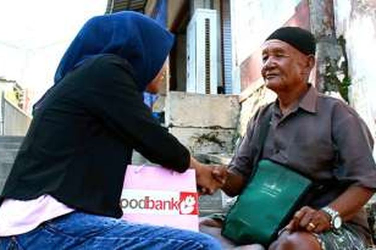Salah satu anggota organisasi Foodbank UISI saat sedang menyantuni warga kurang mampu di Gresik.