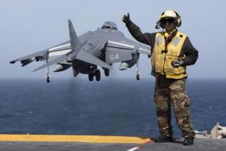 Aviation Boatswain's Mate 2nd Class Christiana Marszalek, memberi sinyal kepada AV-8B Harrier lepas landas dari kapal serbu amfibi USS Kearsarge, 29 Maret 2013 di Laut Mediterania. Pasukan militer AS telah bersiap jika dipanggil untuk menyerang rezim Suriah, kata Menteri Pertahanan Chuck Hagel kepada BBC, 27 Agustus 2013.