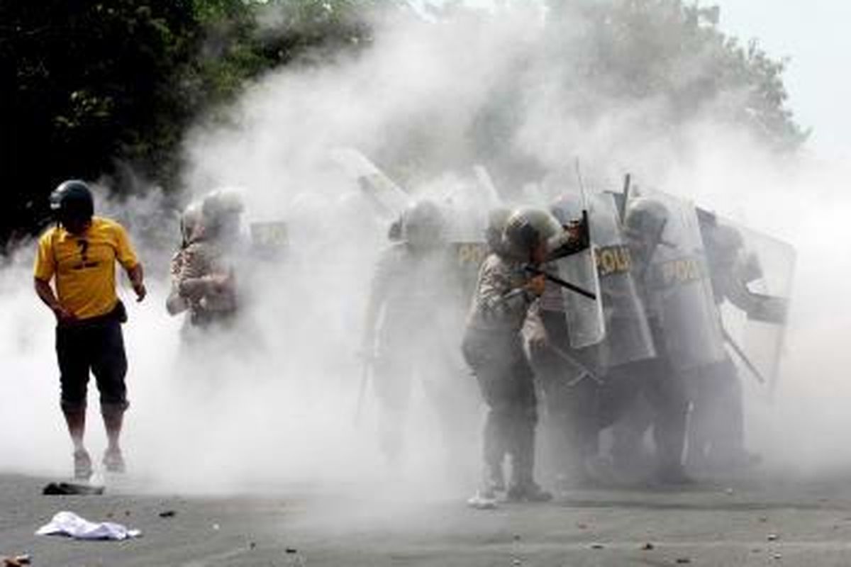 Aparat kepolisian menggunakan tameng untuk menahan lemparan batu dalam peristiwa bentrok dengan para mahasiswa yang berunjuk rasa menentang kenaikan harga bahan bakar minyak di depan kampus  Universitas Negeri Makassar (UNM), Sulawesi Selatan, Kamis (15/5). Sejumlah mahasiswa ditangkap polisi. Tribun Timur/Abbas Sandji (ABS) 15-05-2008