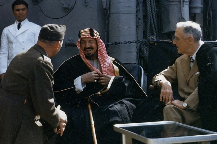 Potret Abdulaziz Al-Saud (tengah) bersama Presiden Amerika, Franklin D. Roosevelet (kanan) di geladak kapal Perang USS Quincy pasca-konferensi Yalta