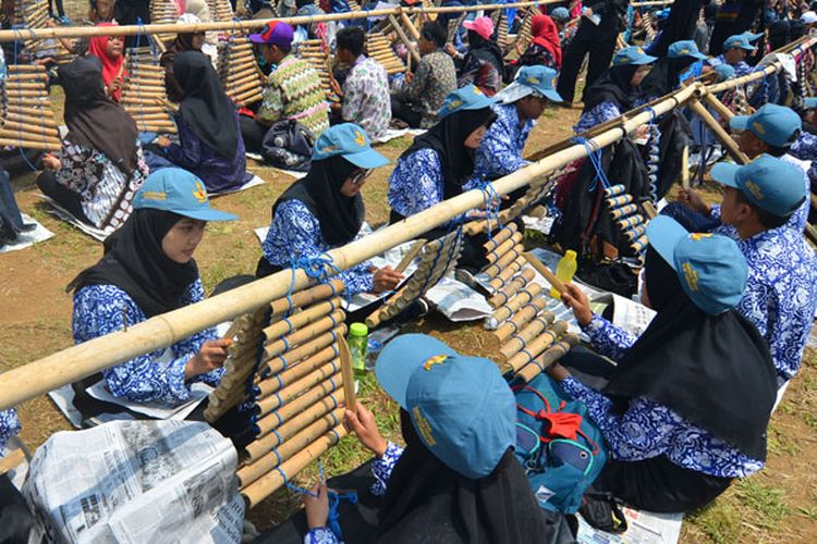 Sejumlah pelajar memainkan alat musik tradisional Calung renteng pada acara Preanger Tourism Fair 2018 di Karangresik, Kota Tasikmalaya, Jawa Barat, Minggu (14/10/2018). Pertunjukan yang dikemas lewat kolaborasi antara calung renteng, angklung, perkusi dan alat musik modern itu dimainkan oleh 1.093 pelajar dari 15 sekolah bertujuan untuk melestarikan calung renteng agar lebih dikenal oleh generasi muda.