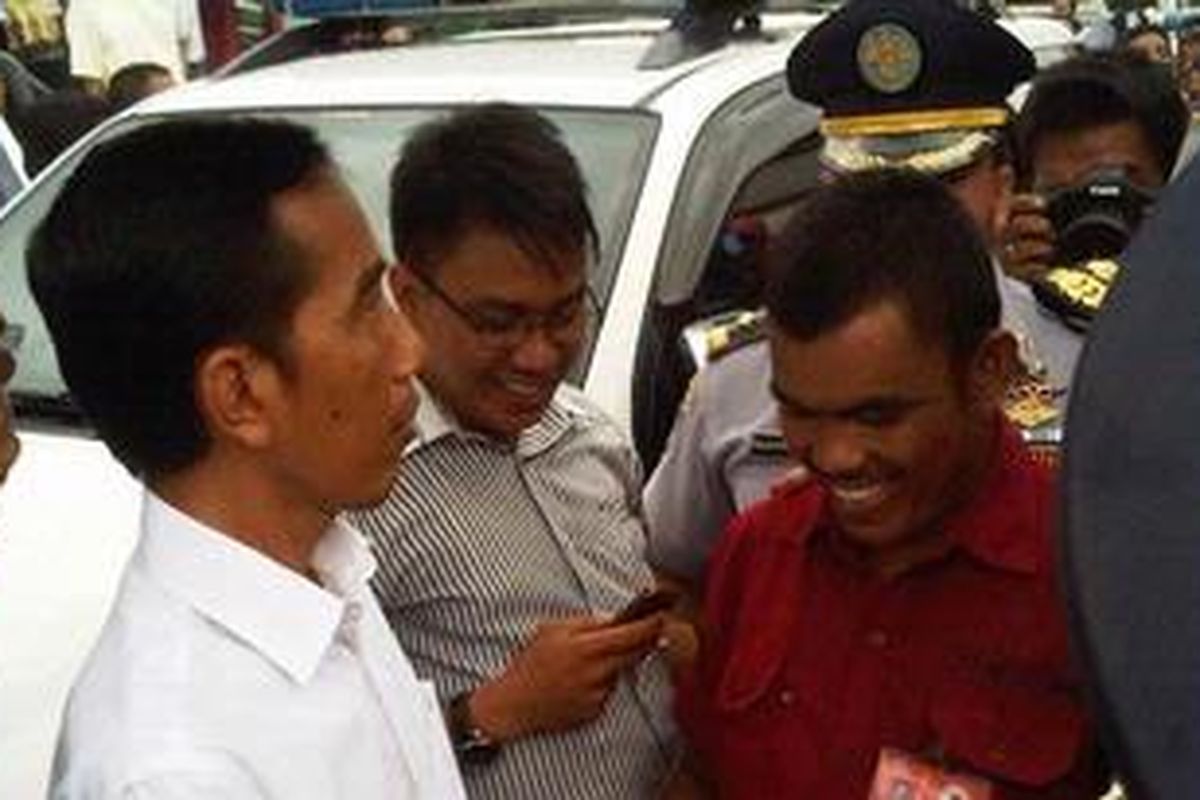 Terlihat Jokowi sedang memasangkan kartu identitas supir bus di terminal senen, Kalis (3/1/2013)