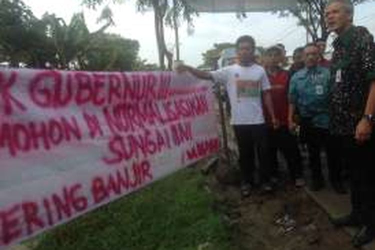 Petani Demak membentangkan spanduk di tengah iringan mobil dinas Gubernur Jateng, Rabu (18/1/2017). Mereka ingin sungainya dinormalisasi sungai ini karena sering banjir.