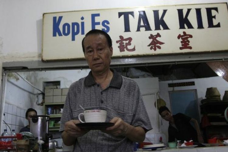 Pemilik kedai kopi es Tak Kie, Latif Yunus Membawa secangkir kopi di kedainya di kawasan Glodok, Jakarta Barat, Jumat (2/5/2014). Kedai kopi tua ini dirintis oleh Liong Kwie Tjong, kakek dari Latif Yunus sejak 1927. 