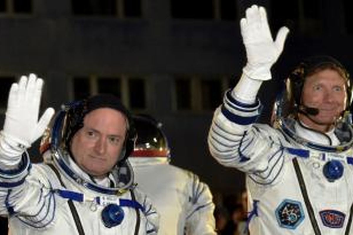 Astronot AS Scott Kelly (kiri) dan kosmonot Rusia Gennady Padalka melambaikan tangan sebelum masuk roket Soyuz-FG di Kosmodrom Baikonur, Kazakhstan, Jumat (27/3/2015).