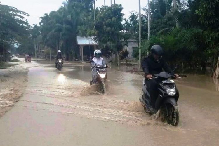 Warga melintasi di lokasi banjir  Desa Dayah KM VI, Kecamatan Lhoksukon, Aceh Utara, Rabu (29/3/2017)