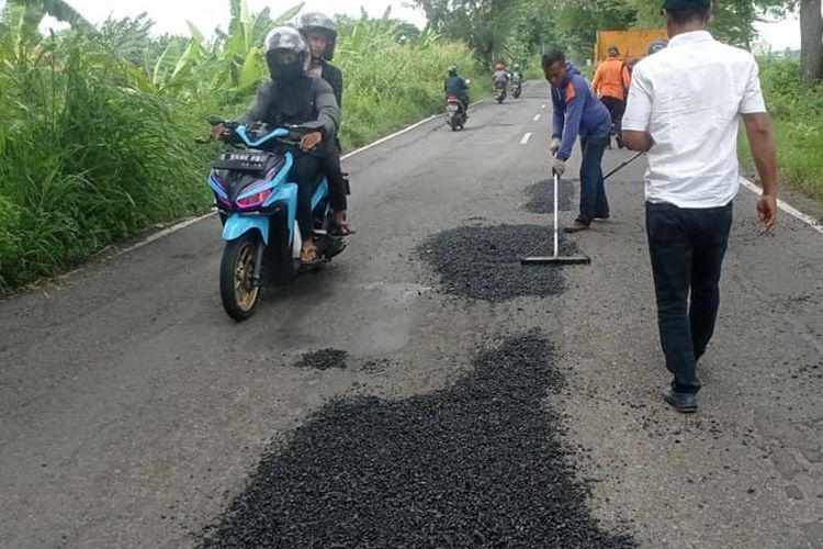 Petugas dari Dinas Pekerjaan Umum (PU) Bina Marga Lamongan, saat memperbaiki ruas Jalan Raya Kecamatan Deket-Karangbinangun, Lamongan, Jawa Timur, usai viral, Rabu (1/2/2023).