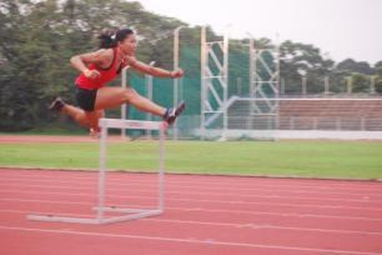 Pelari gawang, Dedeh Erawati, melompati rintangan saat latihan rutin di Stadion Madya, Senayan, Jakarta, Rabu (24/7/2013).