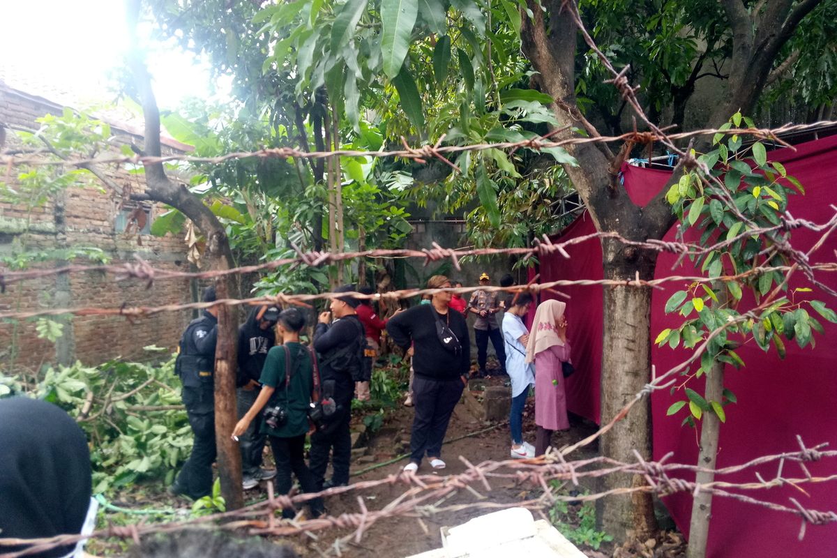 Tampak kerabat dan petugas kepolisian terlihat menunggu pembongkaran makam Lina di luar tenda merah.